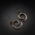 Copper spiral earrings flat lay, grey background, overhead view — Vortex