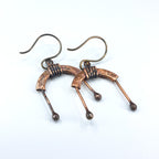 Copper arch earrings flat lay, white background, overhead view — U-Turn