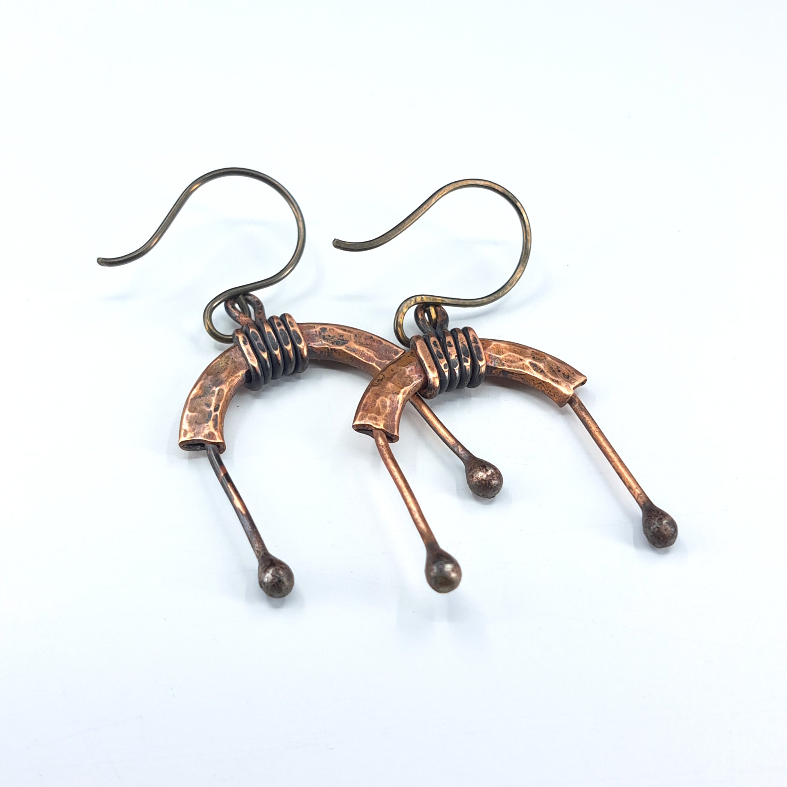 Copper arch earrings flat lay, white background, overhead view — U-Turn