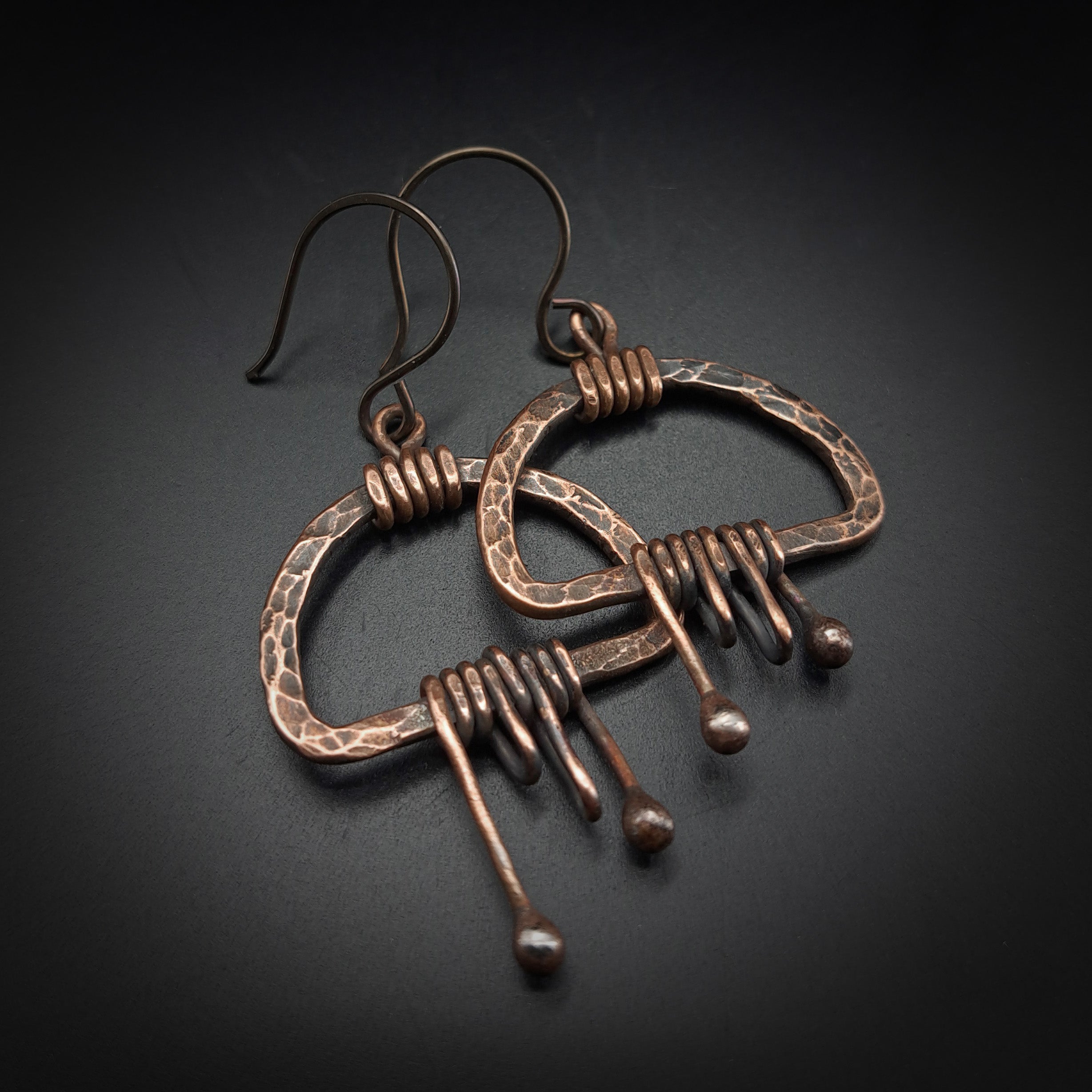 Copper fringe earrings flat lay, grey background, angled view — Nimbus Storm