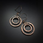 Copper double hoop earrings with coiled wire — dark background