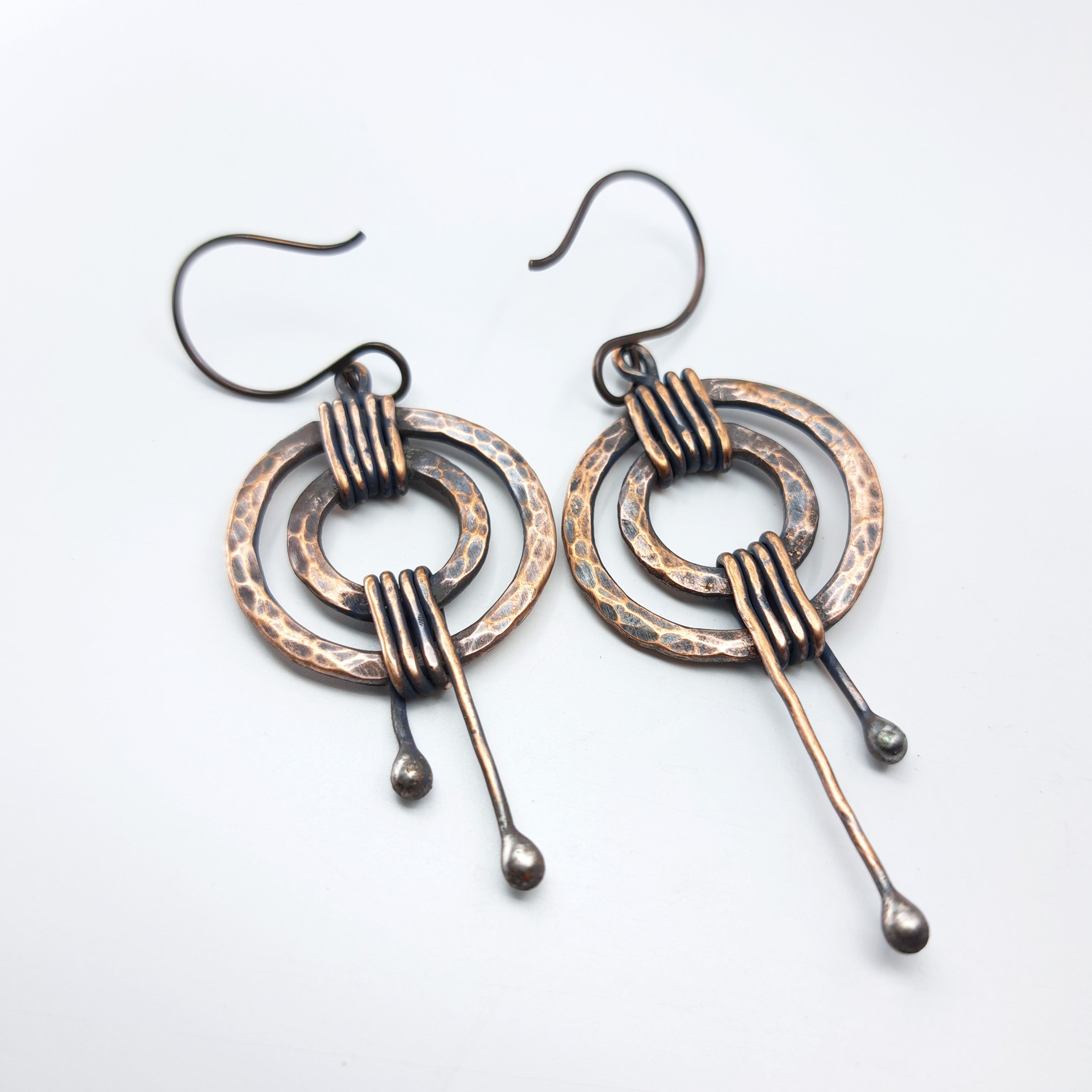 Hammered copper double ring earrings pair, white background — 2¼ inch total length, niobium hooks