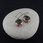 Copper & black onyx earrings flat lay, grey stone background, overhead view — Meridian