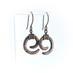 Copper spiral earrings on acrylic stand, white background, front view — Vortex