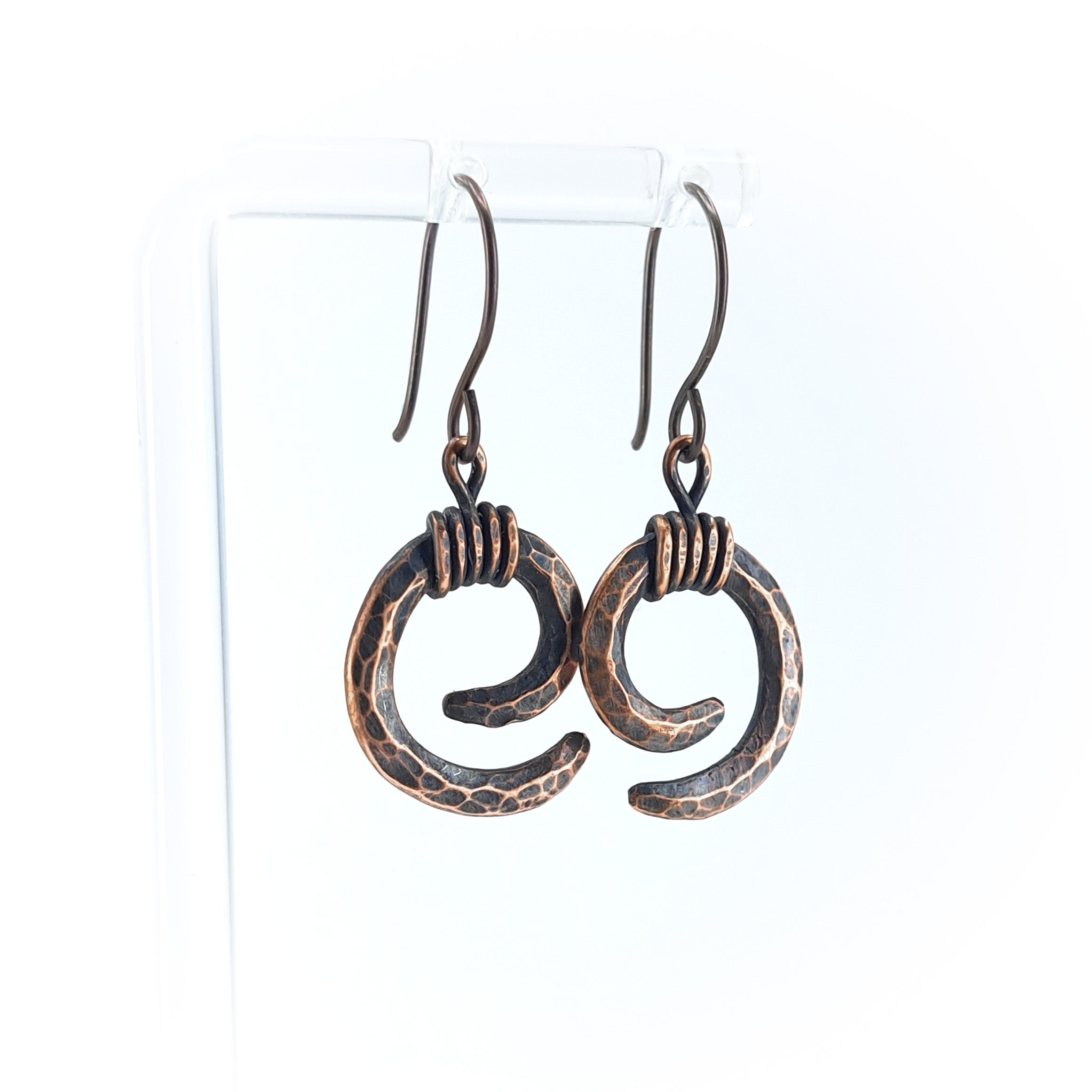 Copper spiral earrings on acrylic stand, white background, front view — Vortex