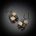 Terra Mosaic earrings on acrylic stand — side view, dark background