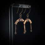 U-shaped copper arch earrings on acrylic stand, dark background — U-Turn