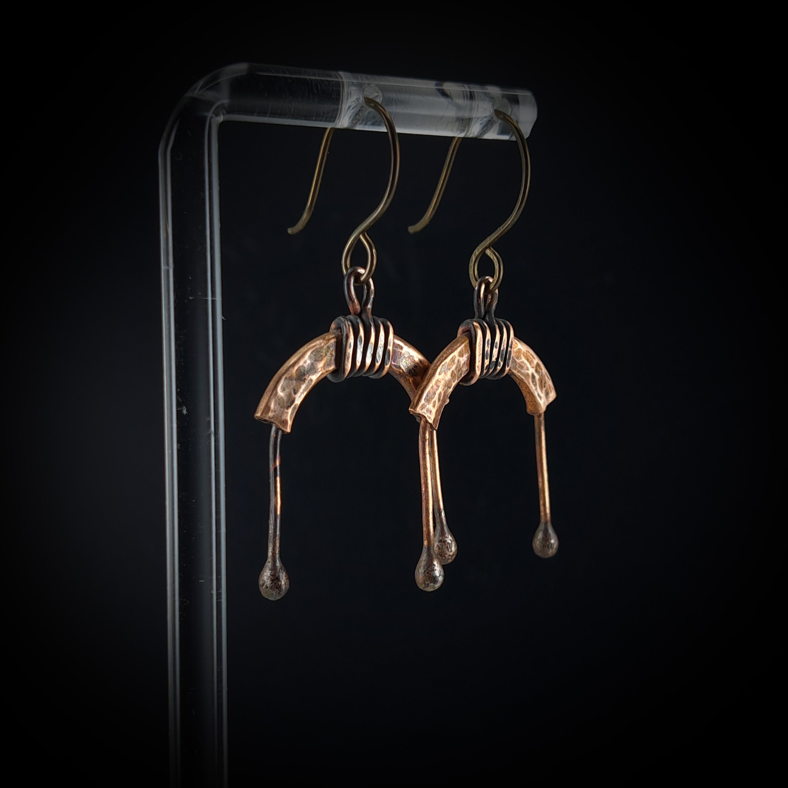 U-shaped copper arch earrings on acrylic stand, dark background — U-Turn