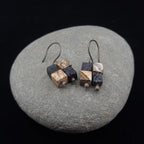 Terra Mosaic earrings on smooth river stone — dark background