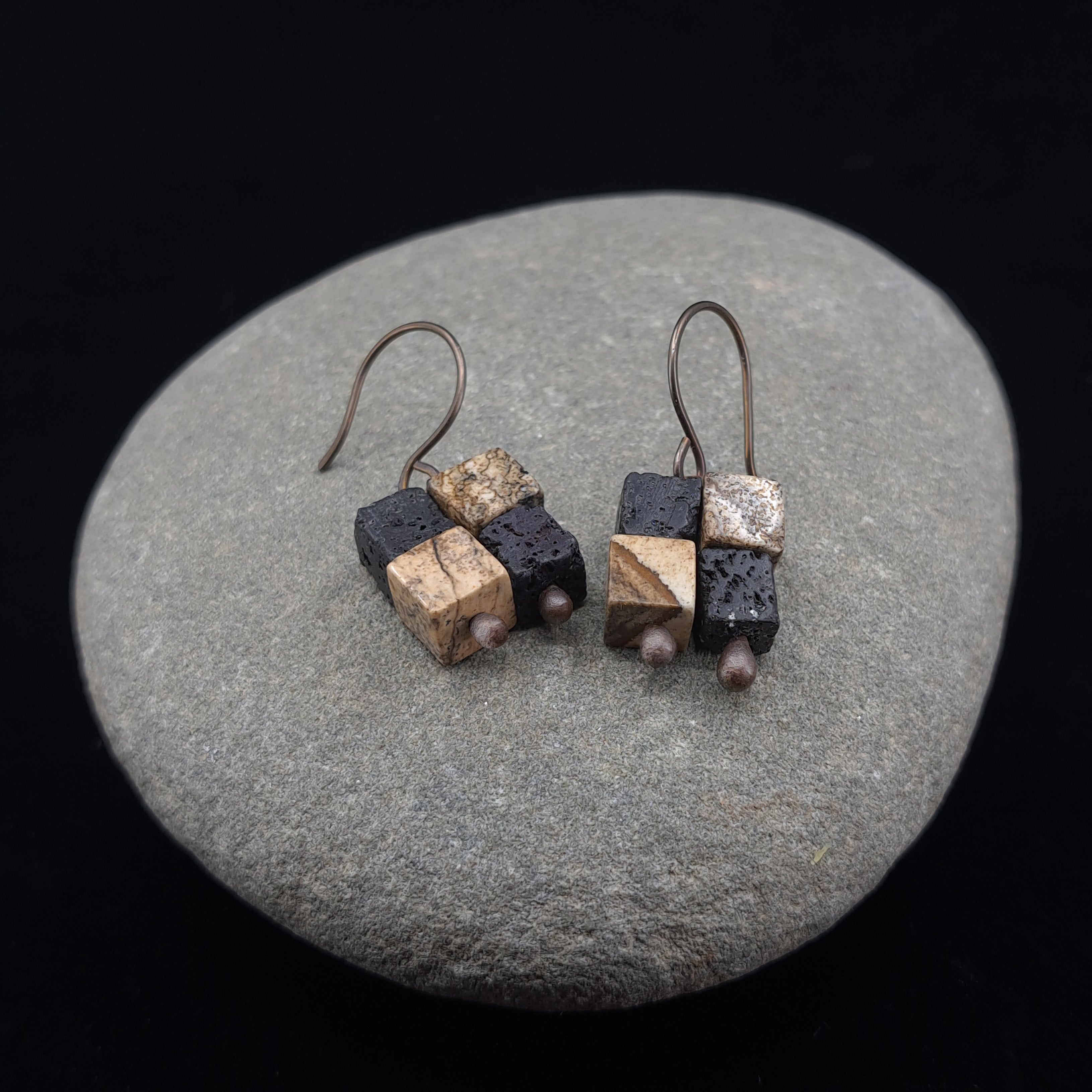 Terra Mosaic earrings on smooth river stone — dark background