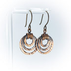 Pair of handmade copper hoop earrings on a white background.