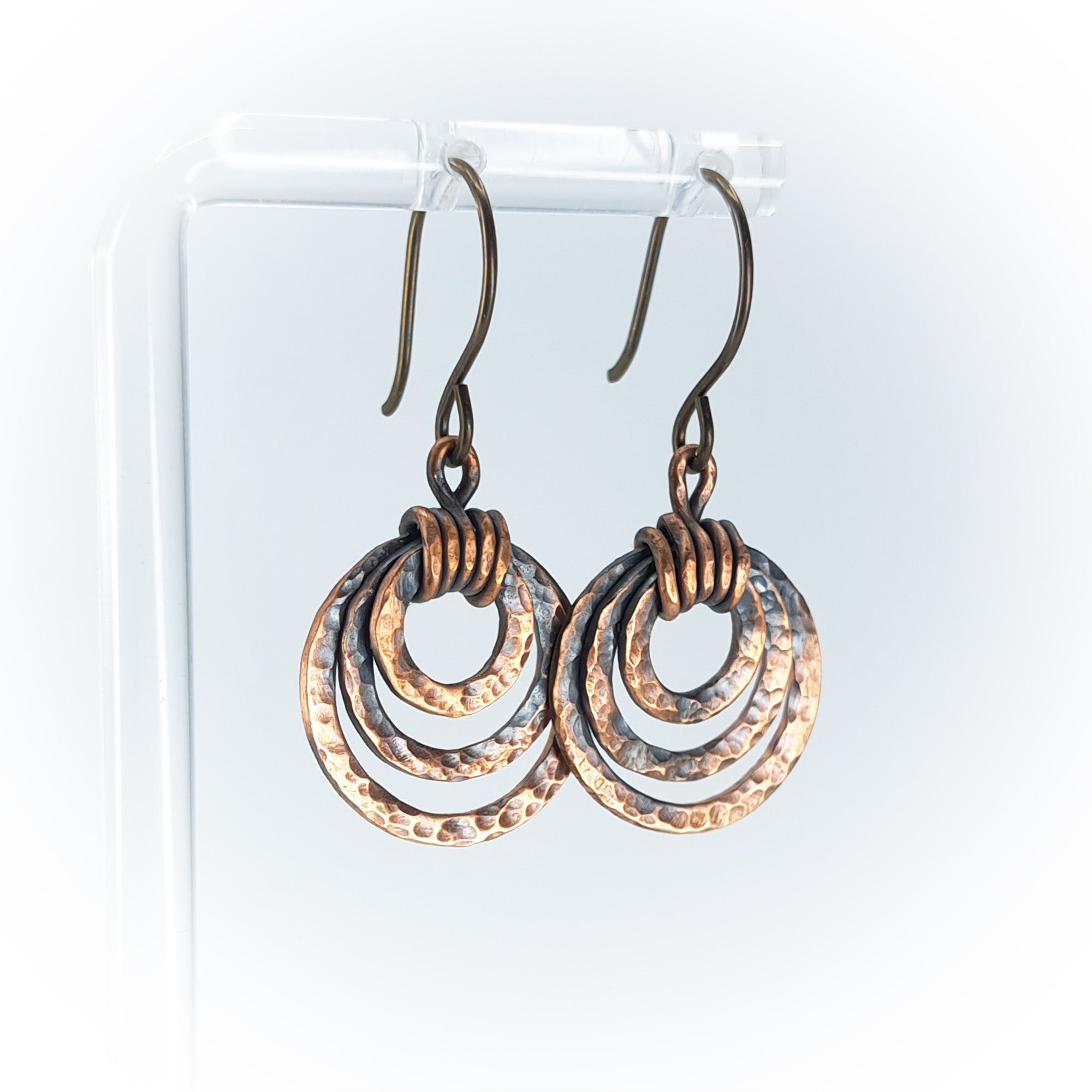 Pair of handmade copper hoop earrings on a white background.