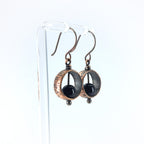 Copper & black onyx earrings on acrylic stand, white background, side view — Meridian