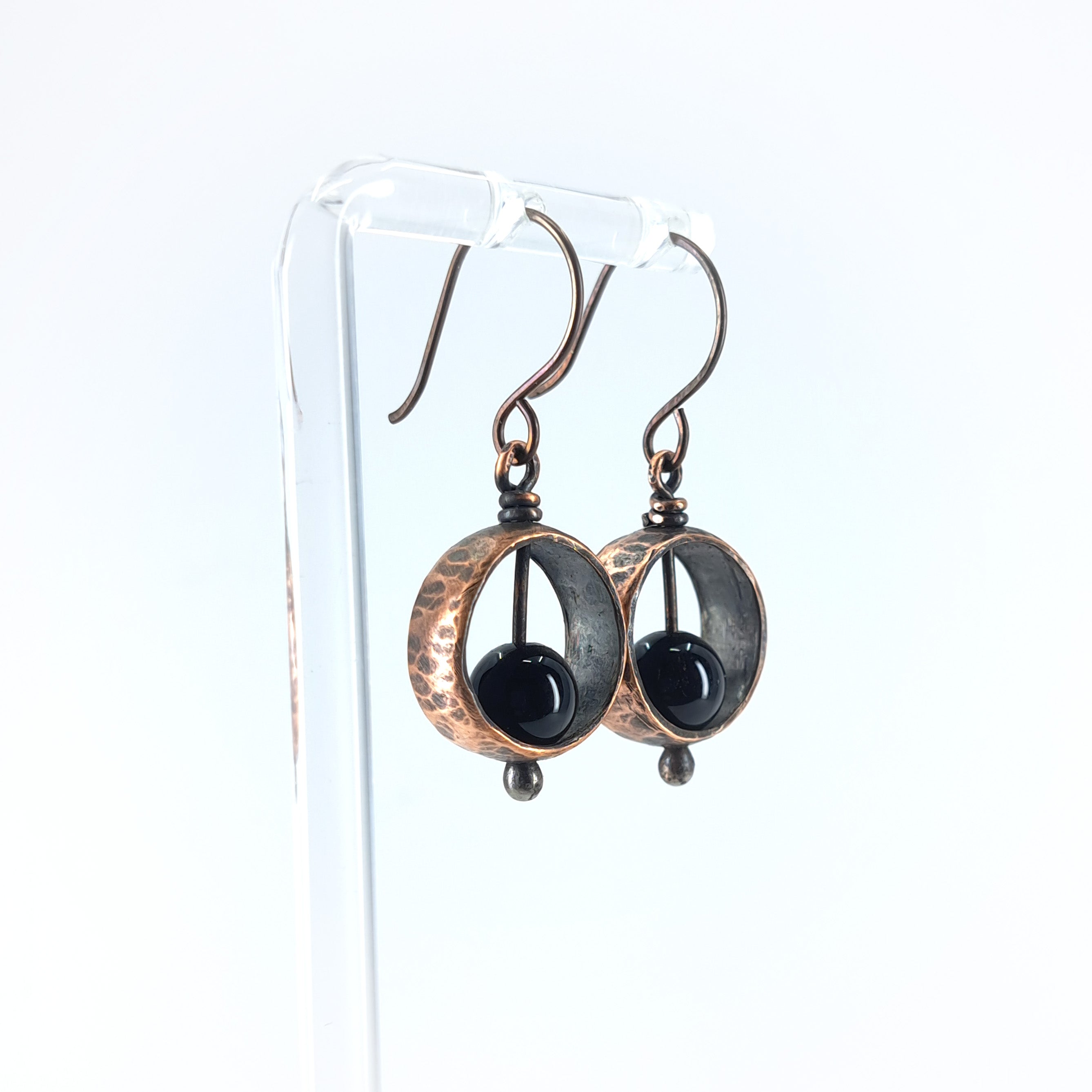 Copper & black onyx earrings on acrylic stand, white background, side view — Meridian