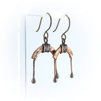 Copper arch earrings on acrylic stand, white background, front view — U-Turn