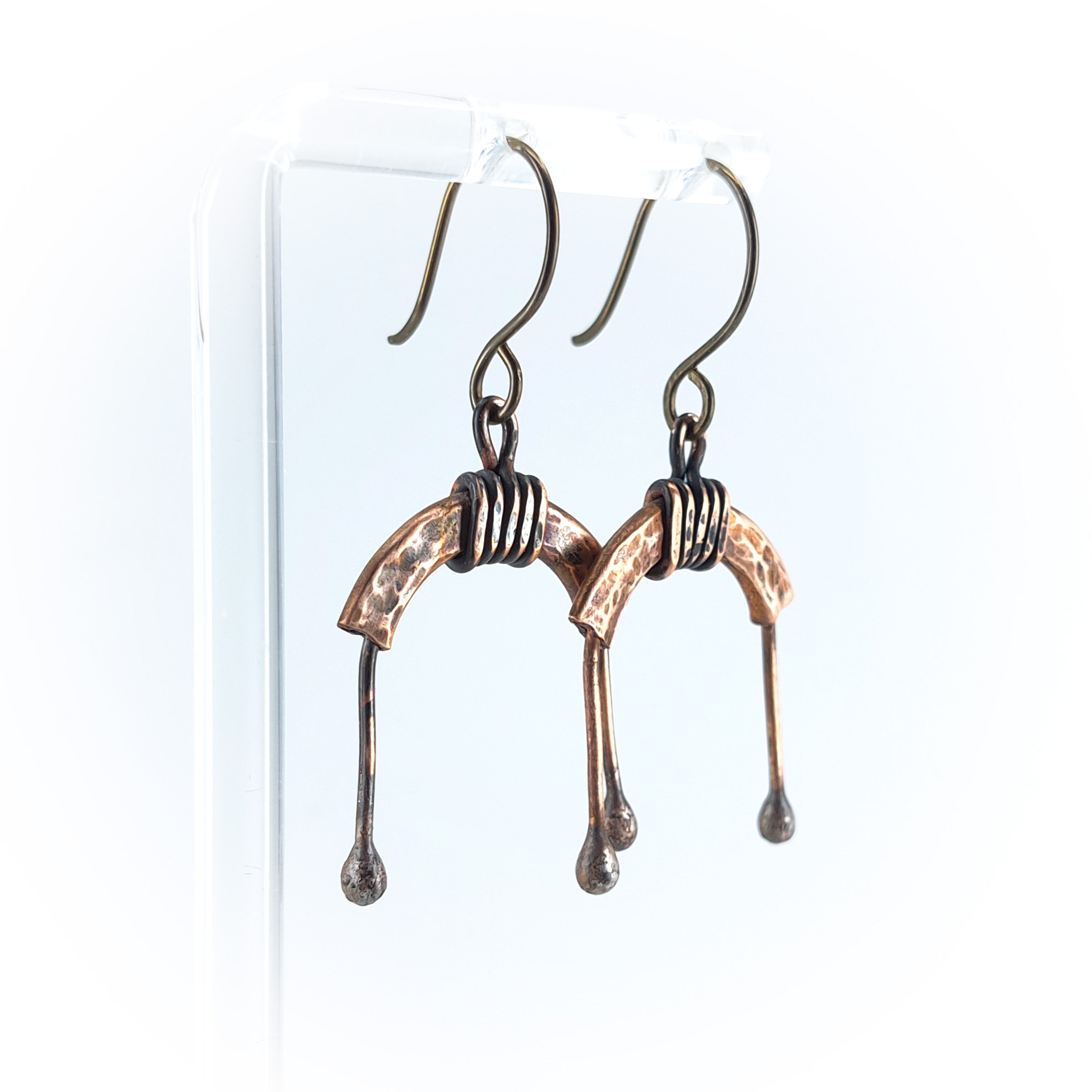 Copper arch earrings on acrylic stand, white background, front view — U-Turn
