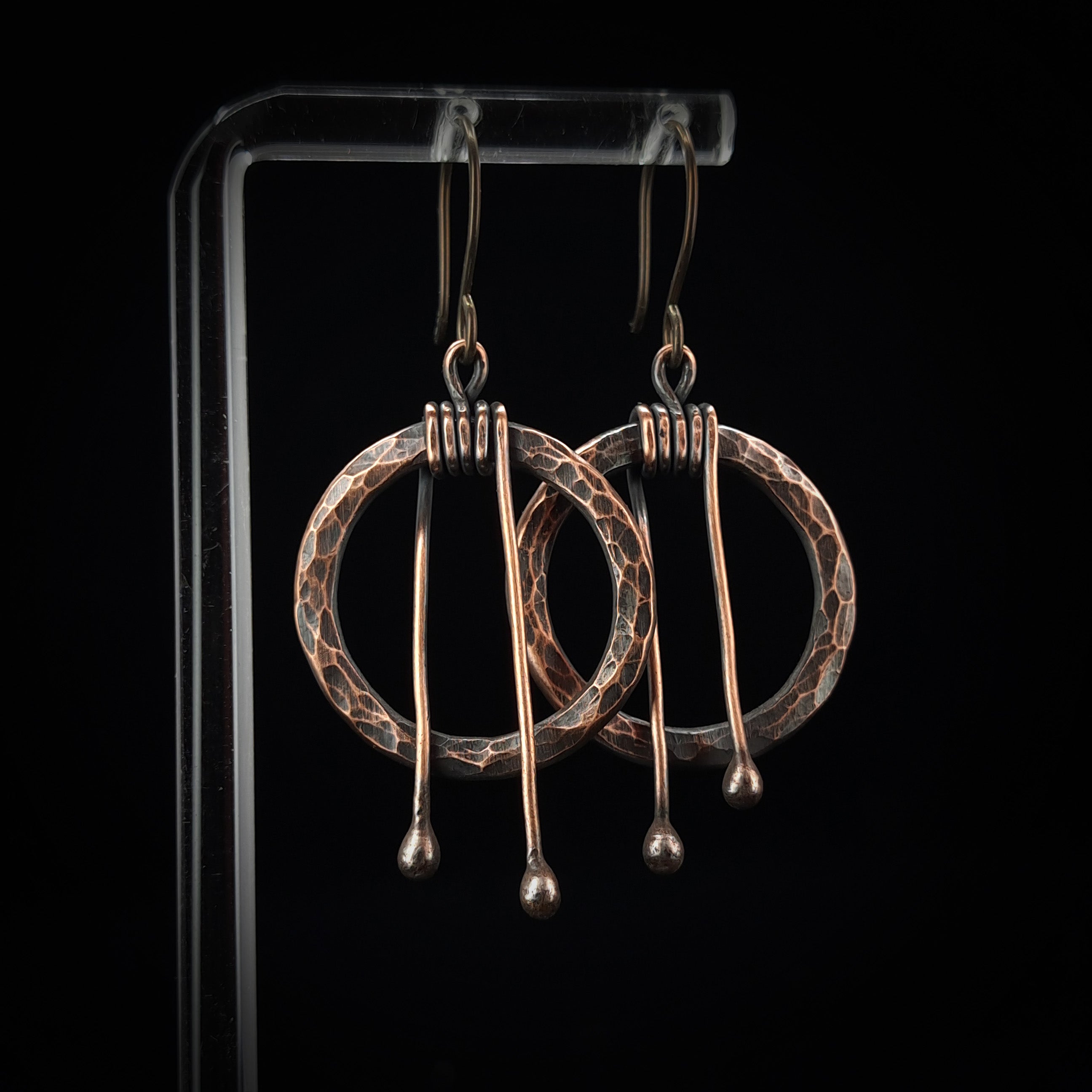 Pair of copper earrings on a black background