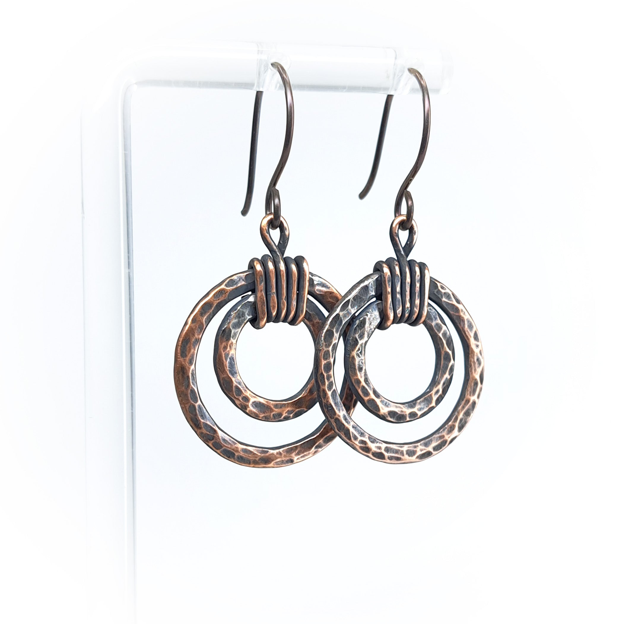 Copper double hoop earrings with coiled wire on white display