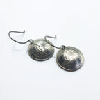 A pair of domed repurposed dime earrings flat lay — white background, angled view
