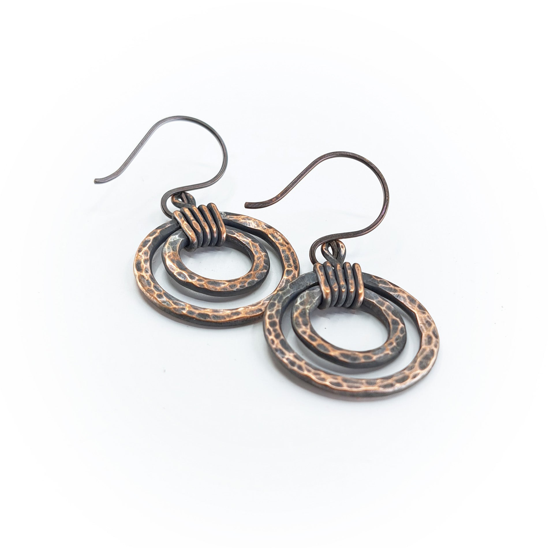 Hammered copper nested hoop earrings — side view on white