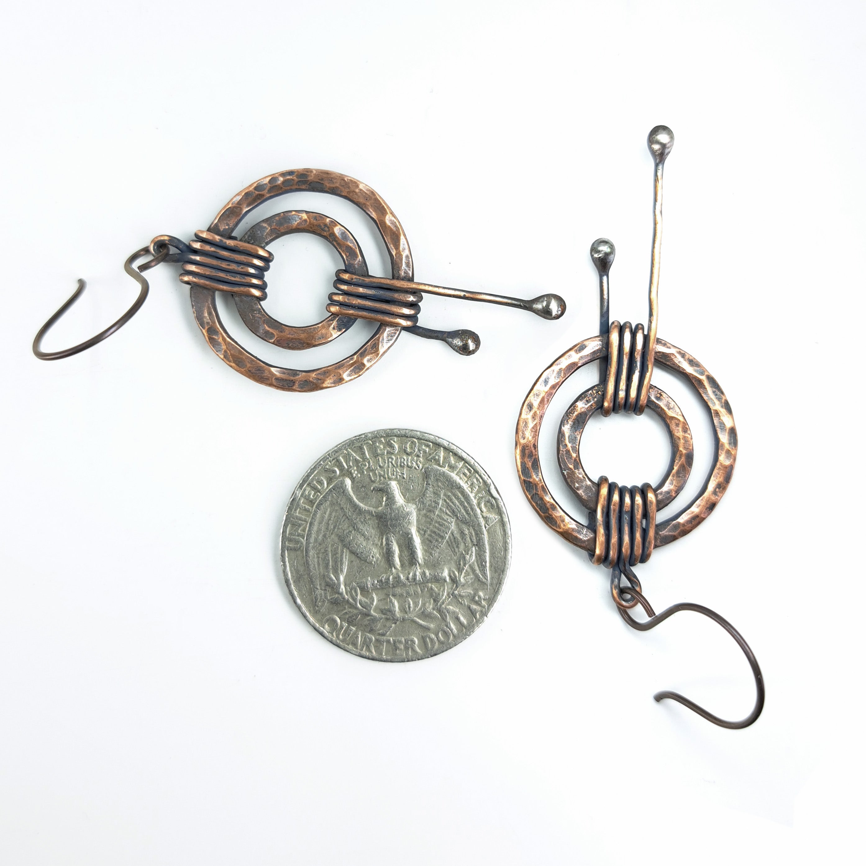 Hammered copper double ring earrings with quarter coin for size reference — ~1 inch diameter, white background